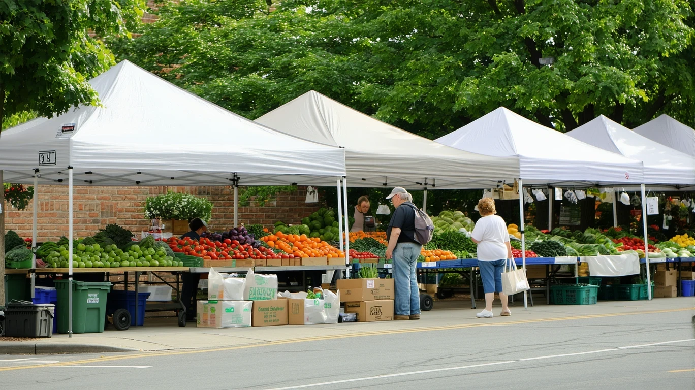 Vendors setting up produce at an outdoor farmer's market on a sunny morning.