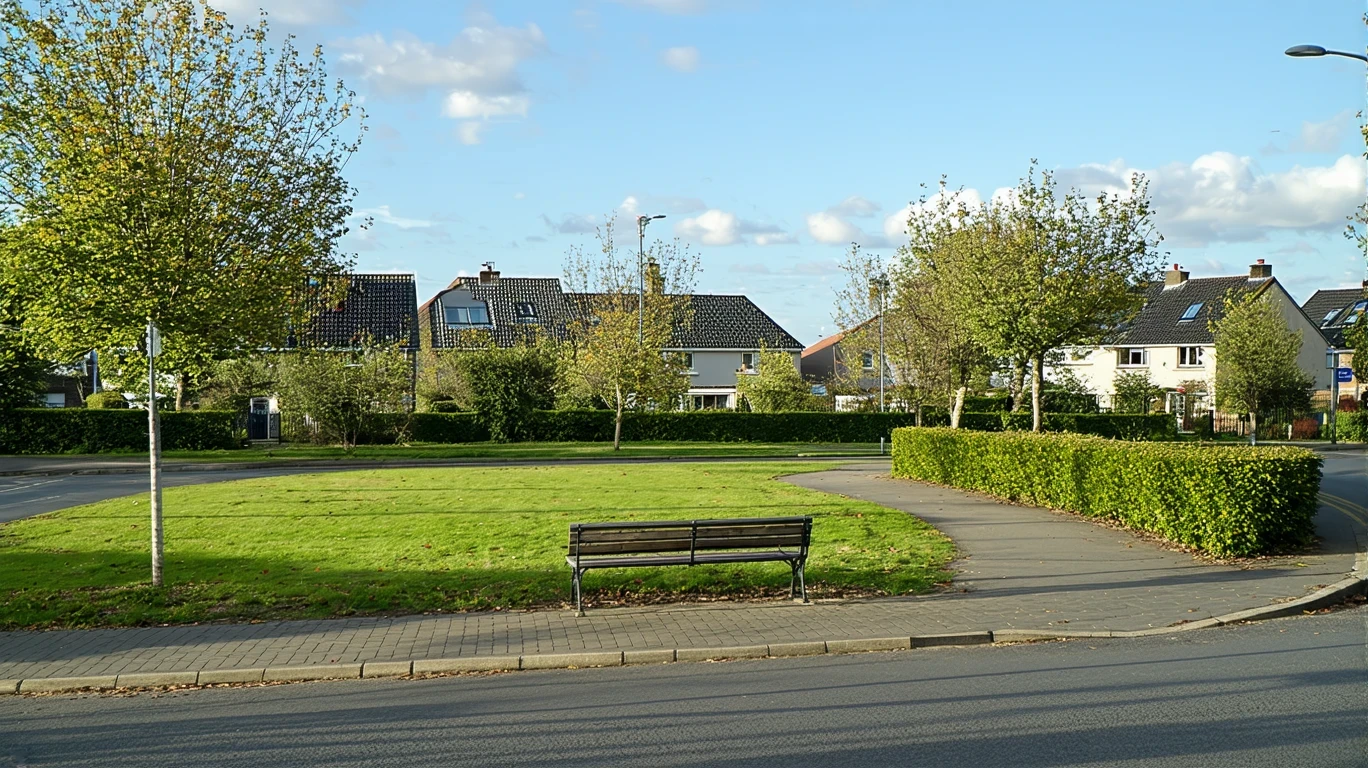 A view across the street of a manicured neighborhood park with a bench and path in Dublin, Ohio.