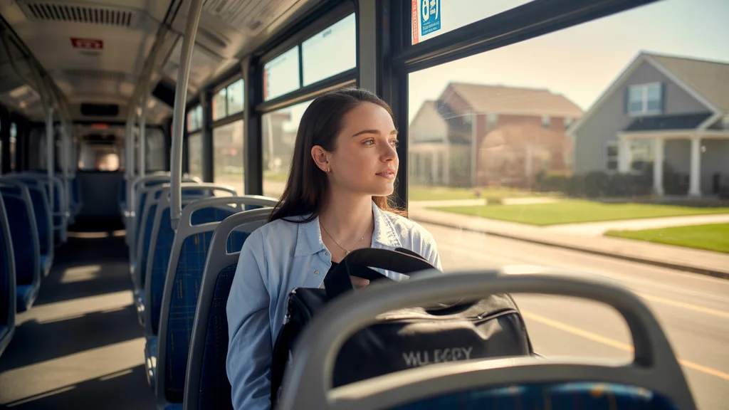 A young woman commuting alone on a nearly empty Valley Metro bus in Mt Juliet, TN on a quiet weekday morning.